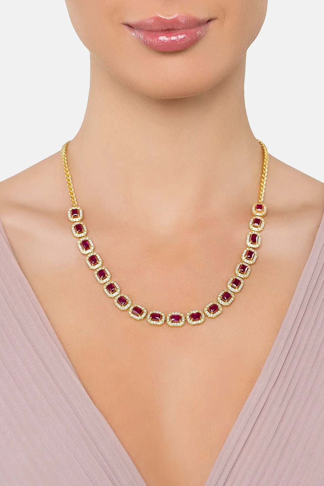 Gold necklace with purple square gemstones worn at the collar