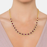 Gold necklace with purple square gemstones worn at the collar