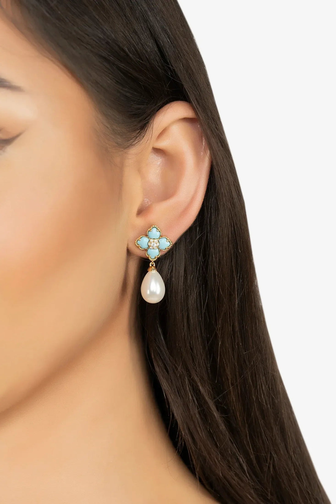 Gold flower clover drop earrings with turquoise enamel and white pearl on ear