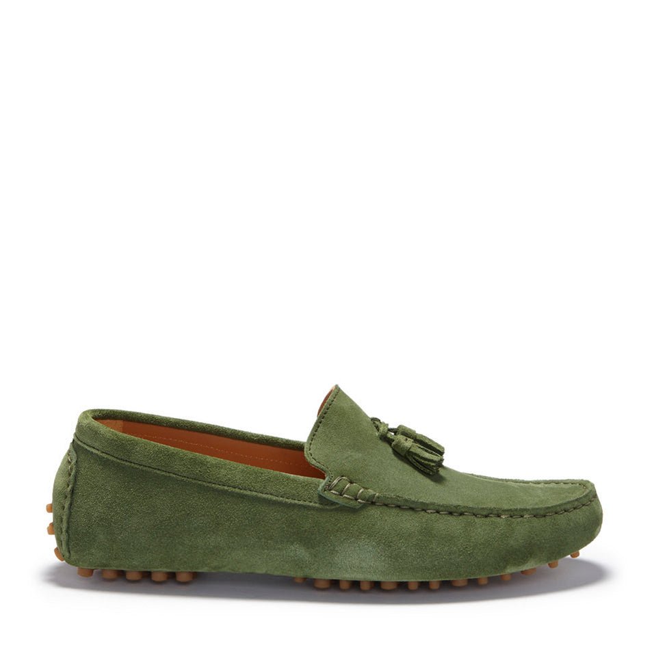 Side view of a green suede driving loafer with tassels and studded sole