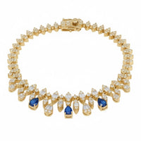 Gold tennis bracelet with clear stones and blue sapphire accents