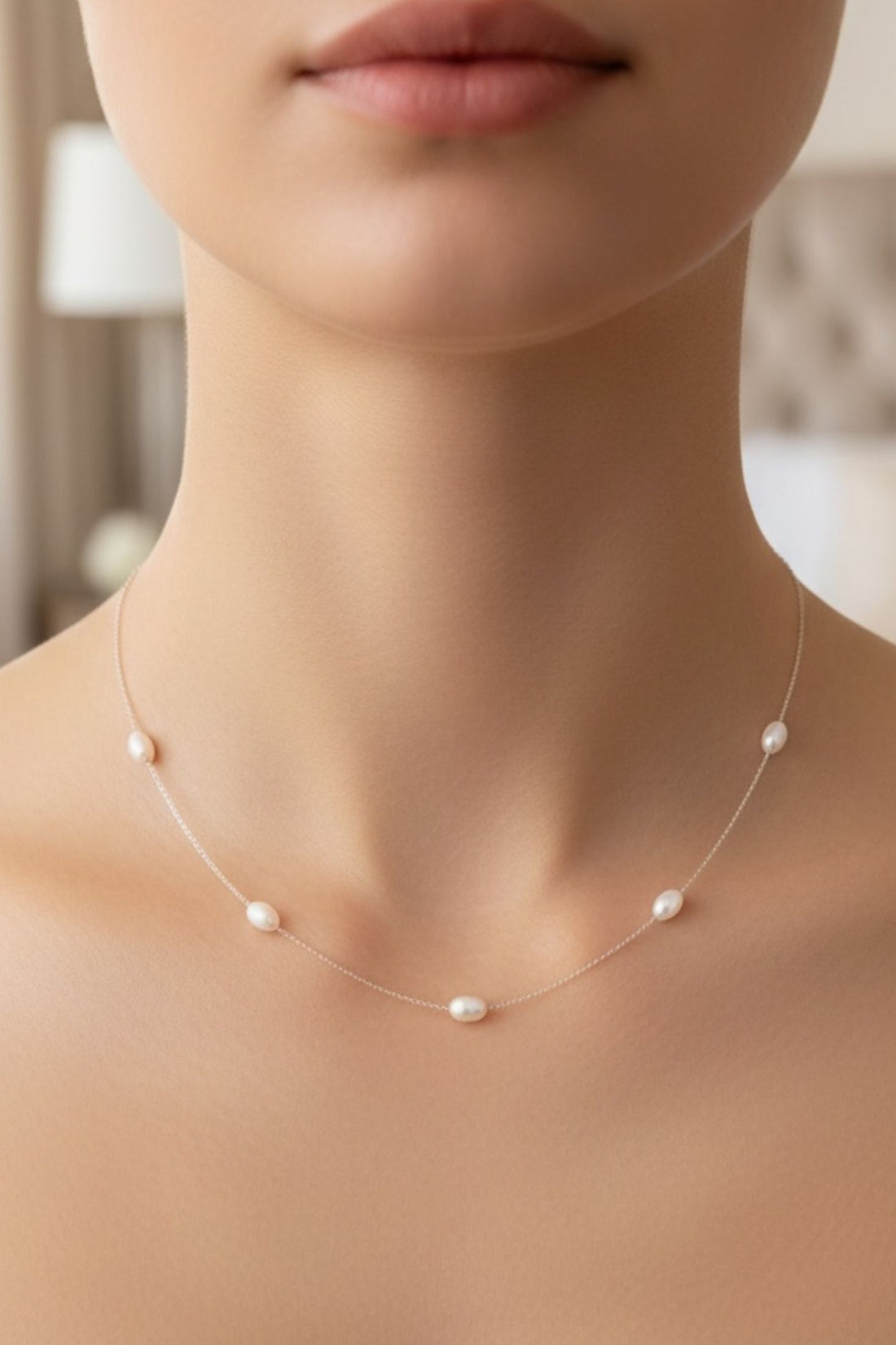 Natural pearl station necklace on a white gold chain, close-up on neckline