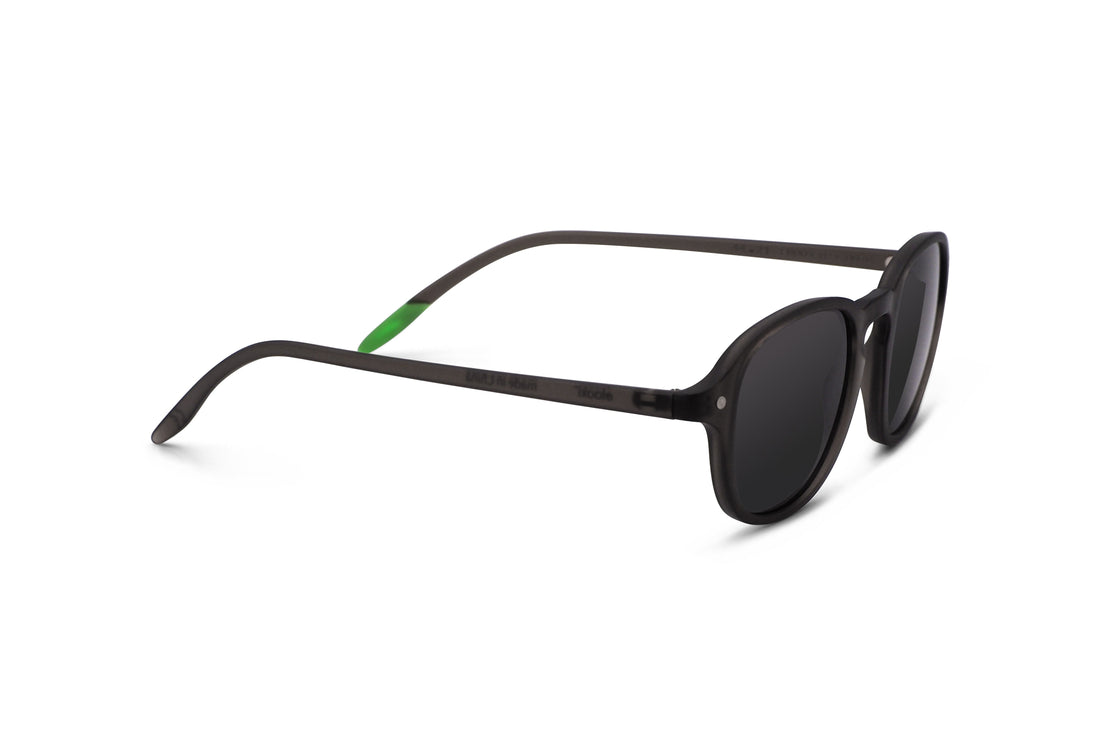 Three-quarter view of dark tinted sunglasses with black frame and green temple accents