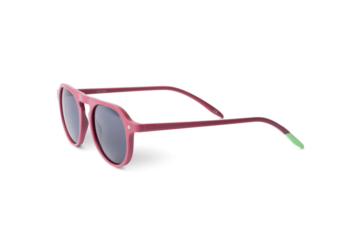 Raspberry pink rounded sunglasses with dark lenses, angled side view