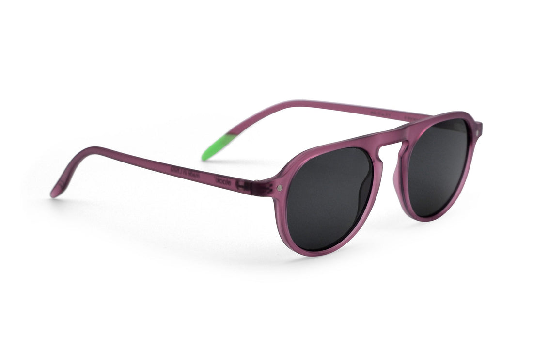 Plum sunglasses, side view, dark lenses and thin green temple accents