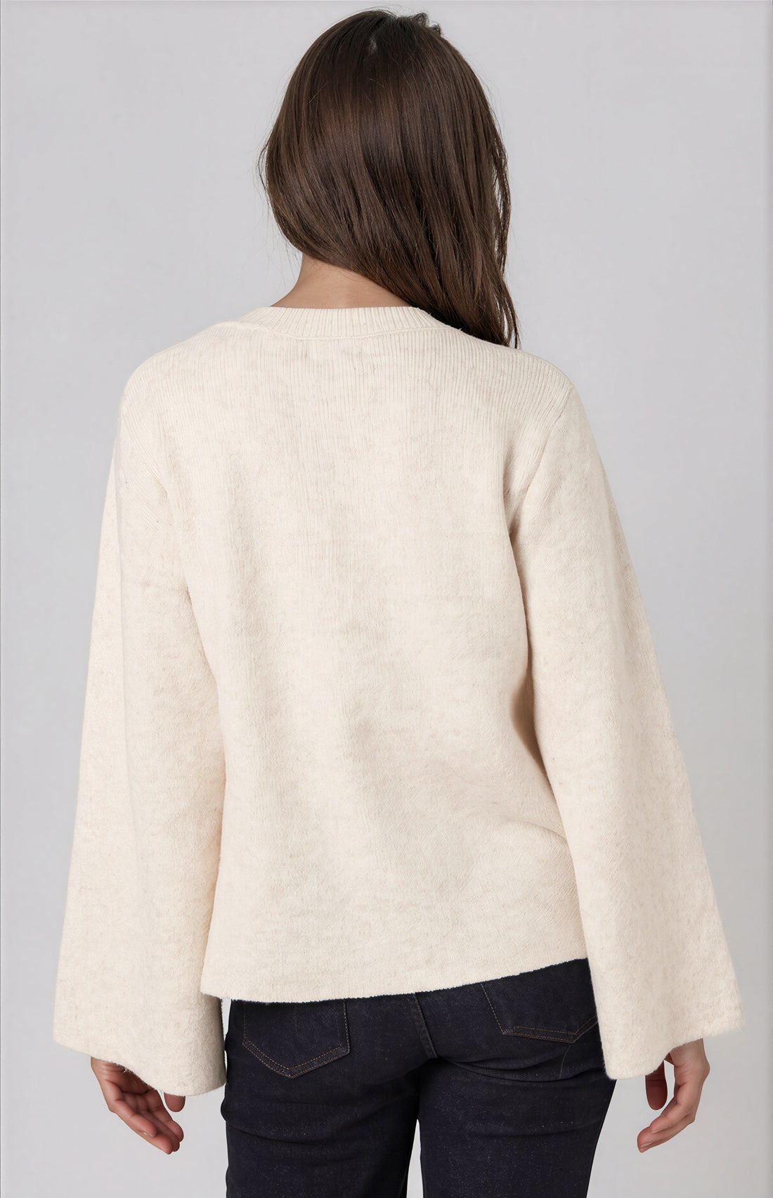 Beige knit cardigan back view with long wide sleeves and center seam