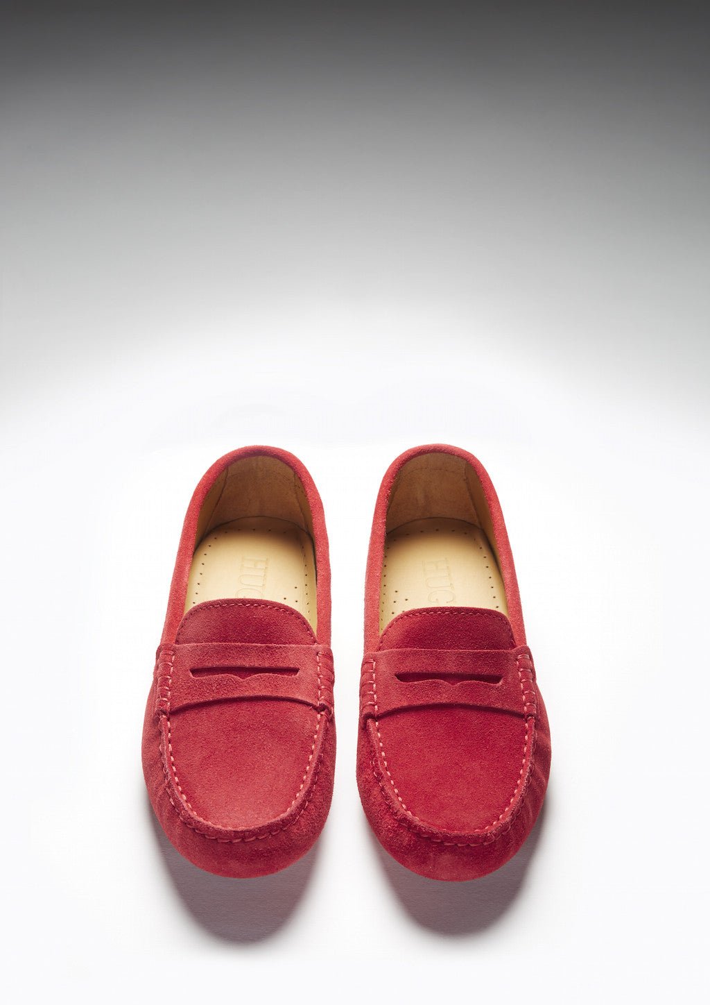 Pair of red suede loafers shown from the front, with penny straps and rounded toes