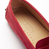 Red suede loafer detail showing the Hugs & Co. branded insole and penny strap
