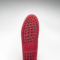 Red loafer outsole with rows of black rubber driving studs