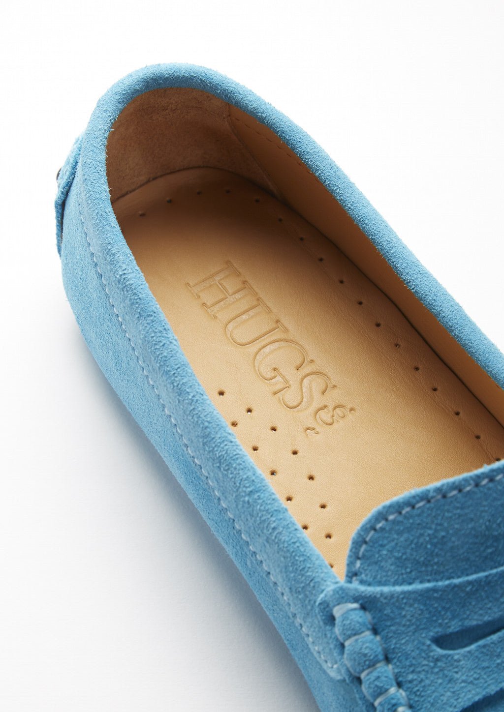 Turquoise suede loafer close-up showing perforated tan insole and stitched trim