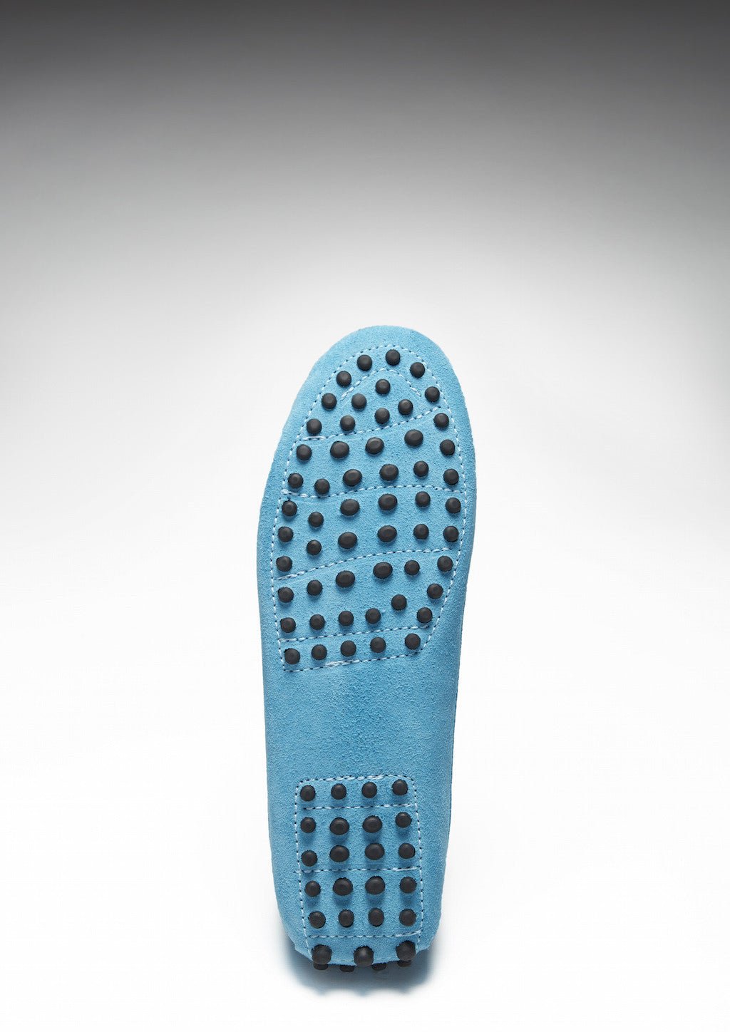 Turquoise suede loafer sole with rows of black rubber driving pods