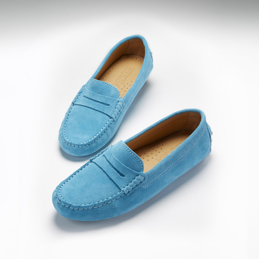 Pair of turquoise suede penny loafers with tan insoles and stitched apron toes