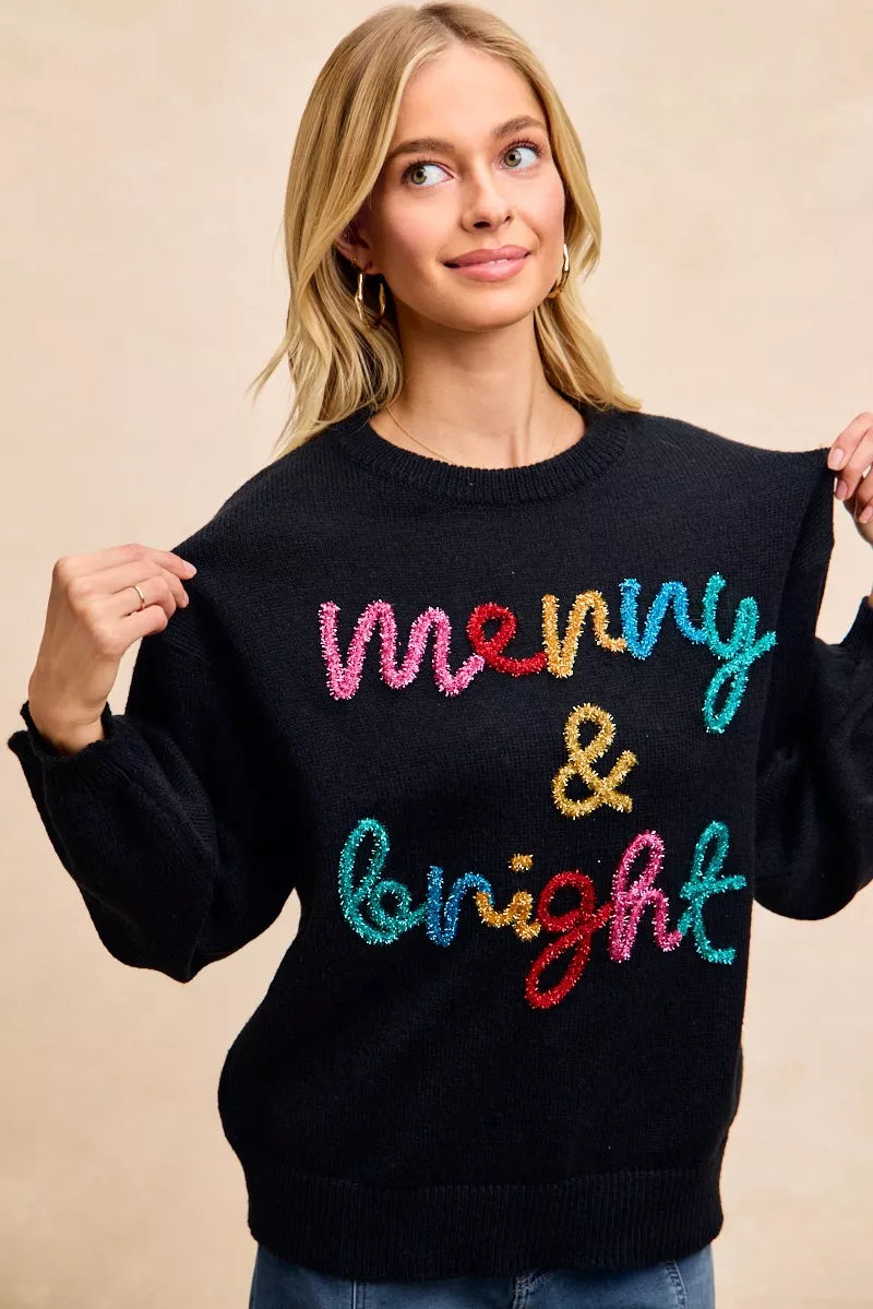 Black pullover sweater with multicolor tinsel "Merry & Bright" lettering front