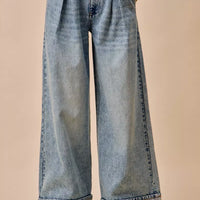 Light-wash mid-rise denim jeans with pleated front and wide straight legs, back view