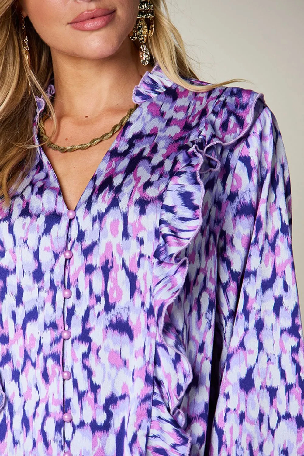 Purple printed shirt close-up with ruffled neckline and button front
