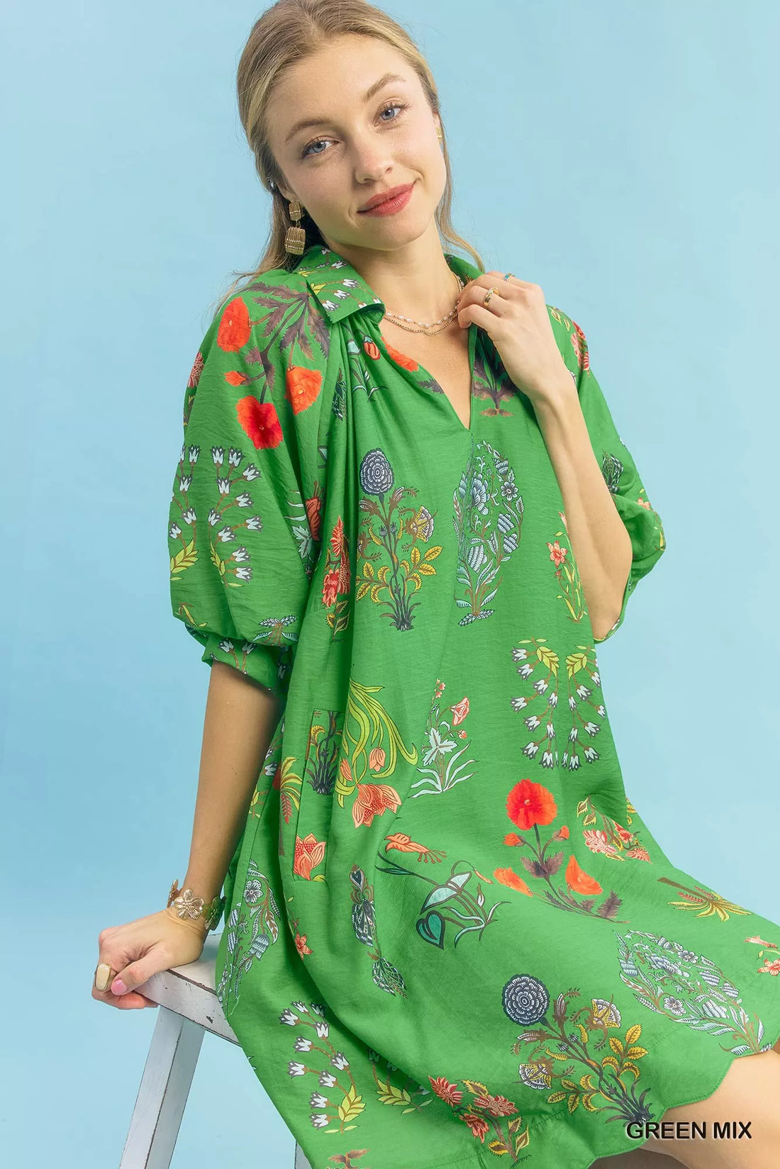 Green floral mini dress close-up, V-neck with puff sleeves and colorful print