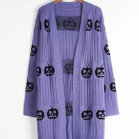 Purple long open-front knit cardigan with black jack-o-lantern print, on hanger
