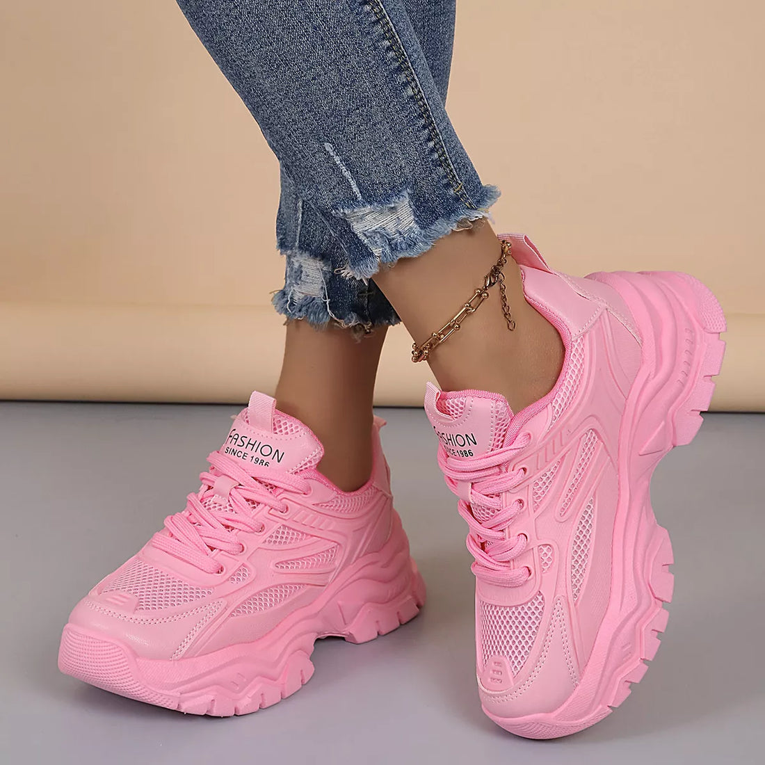 Pink chunky platform sneakers, lace-up with mesh panels and ridged chunky sole.
