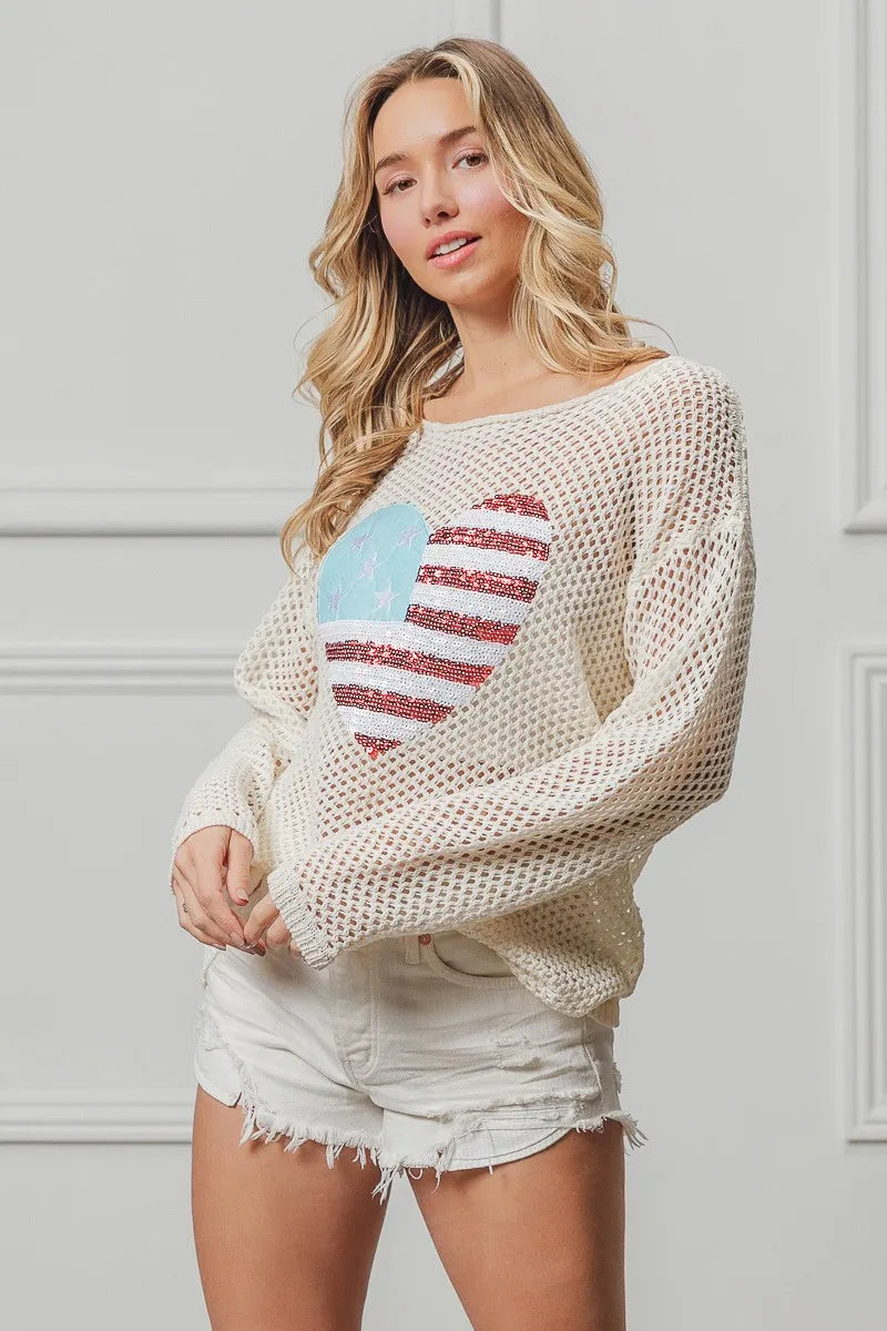 Off-white knit sweater featuring American flag heart sequin design, long sleeves.