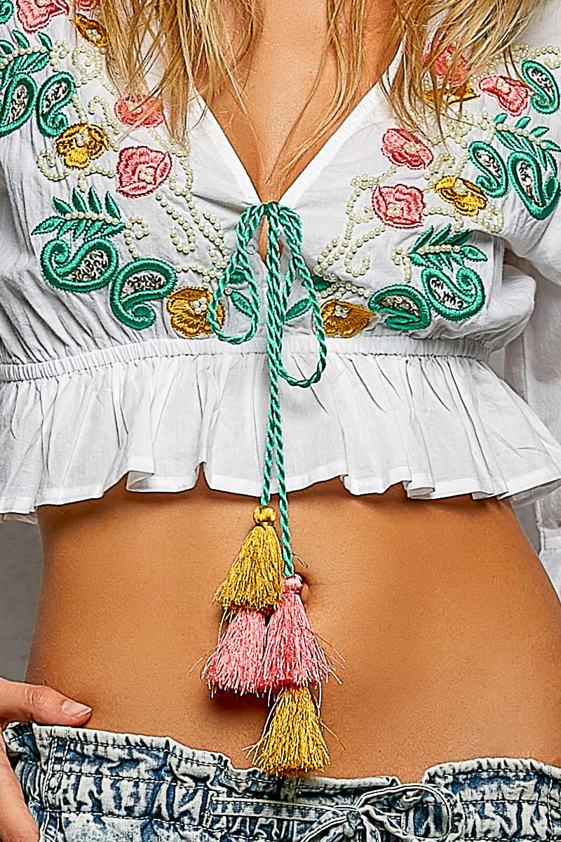 Ivory blouse neckline with colorful floral embroidery and tassel drawstring