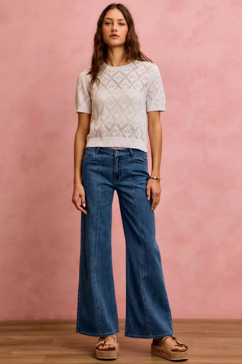 Mid-rise stretch denim jeans with wide flared legs and centered front seam