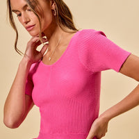 Hot pink ribbed knit peplum sweater top with short sleeves and ruffled hem