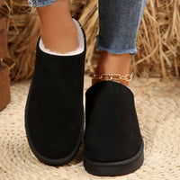 Pair of black plush lined ankle boots with round toe, back view of cushioned collar.