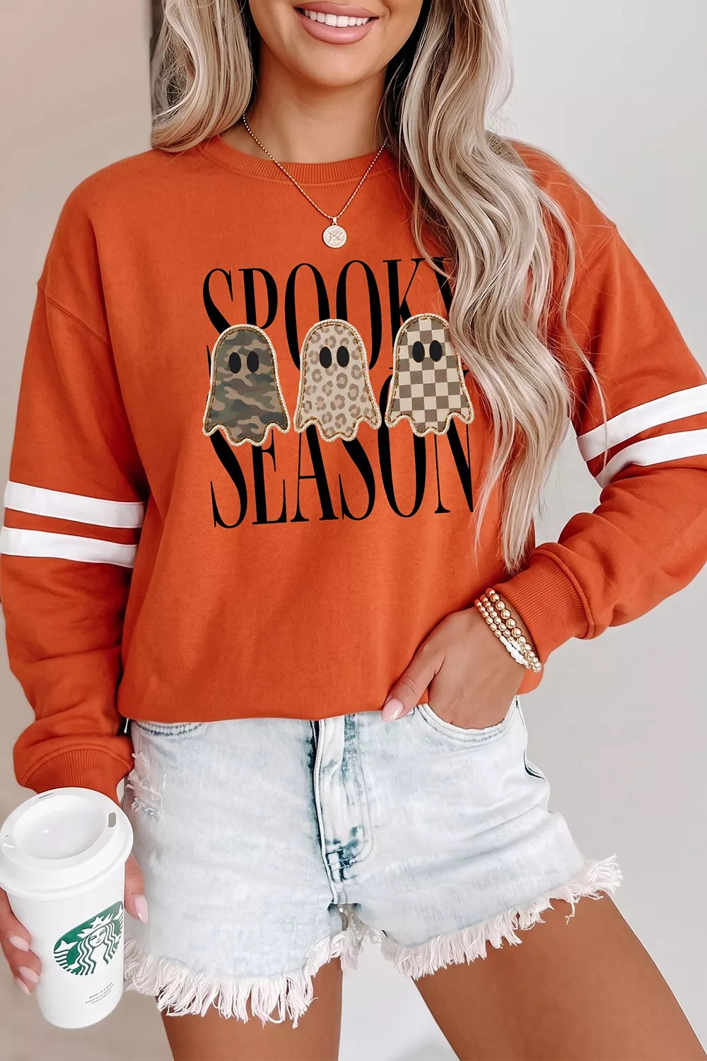 Orange Halloween pullover with ghost graphic and white stripe sleeve detail