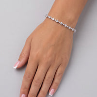 Tennis bracelet with oval stones on wrist, chain links and clasp