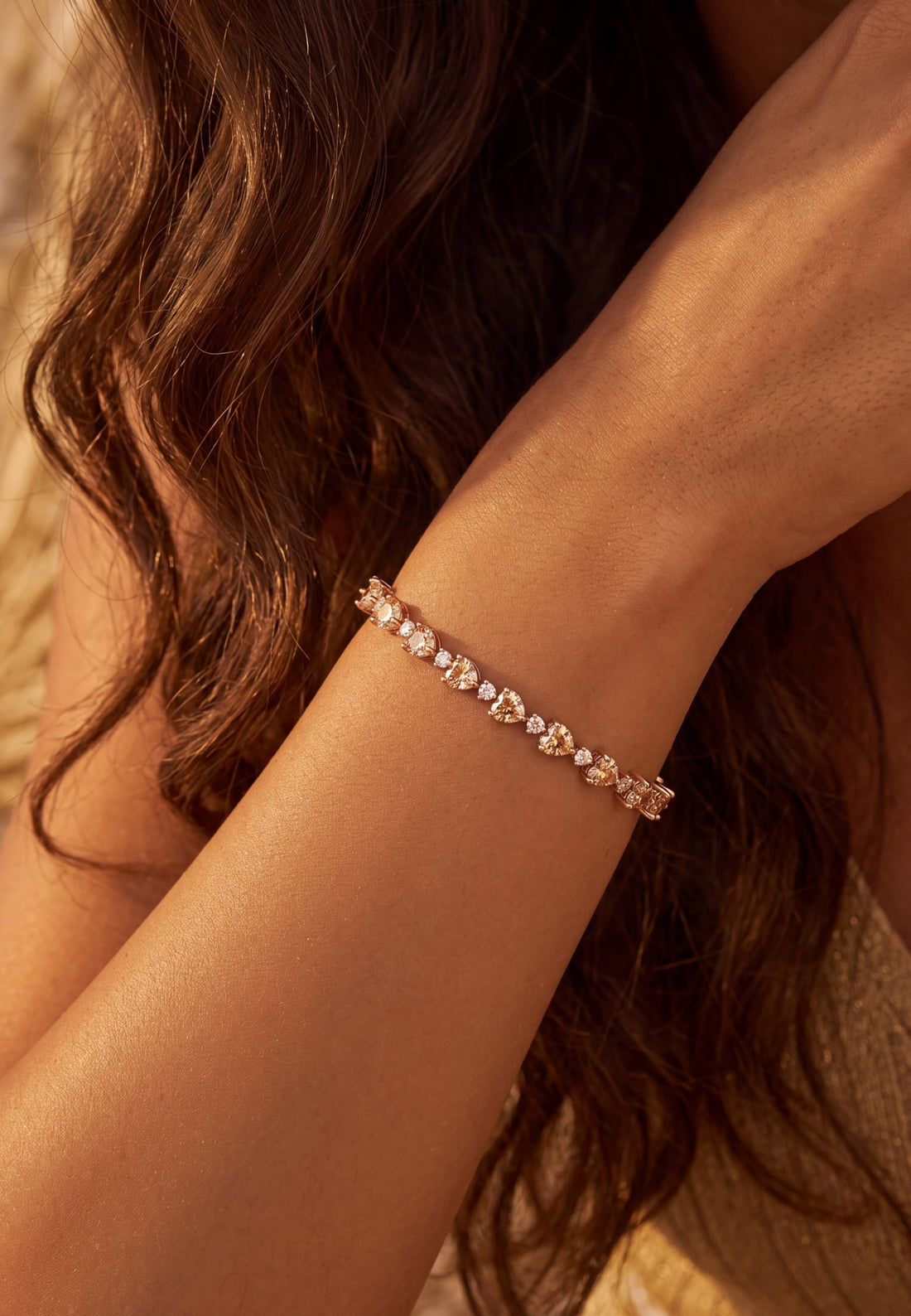 Heart tennis bracelet with oval stones on wrist, close-up
