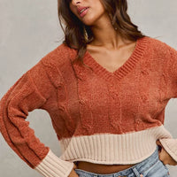 Rust V-neck chenille knit sweater with cream contrast waistband and ribbed cuffs