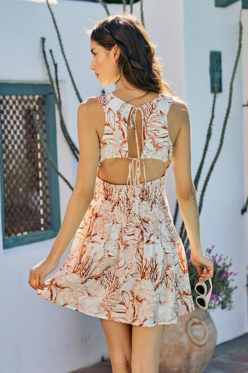 Back and side view of lined mini dress with coral-brown shell print, smocked bodice