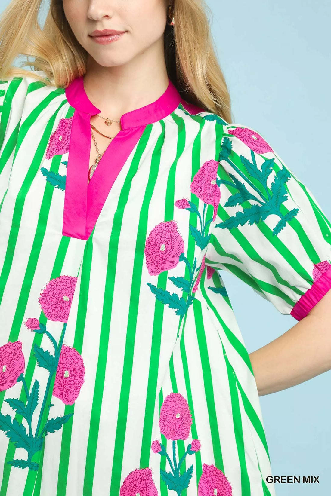 Green striped floral dress detail with pink neckline trim and cactus print