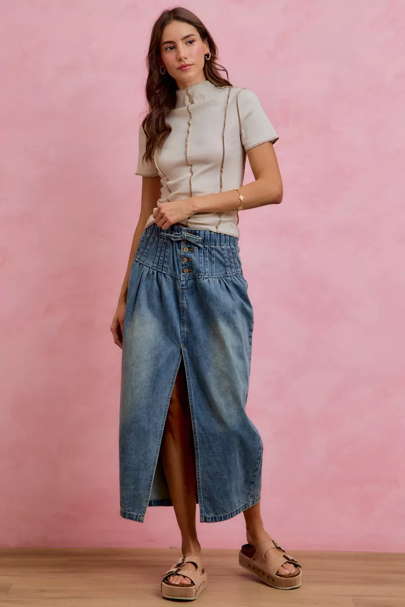 Washed denim midi skirt with front slit and button waistband, worn