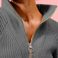 Charcoal half-zip sweater neckline and zipper pull detail
