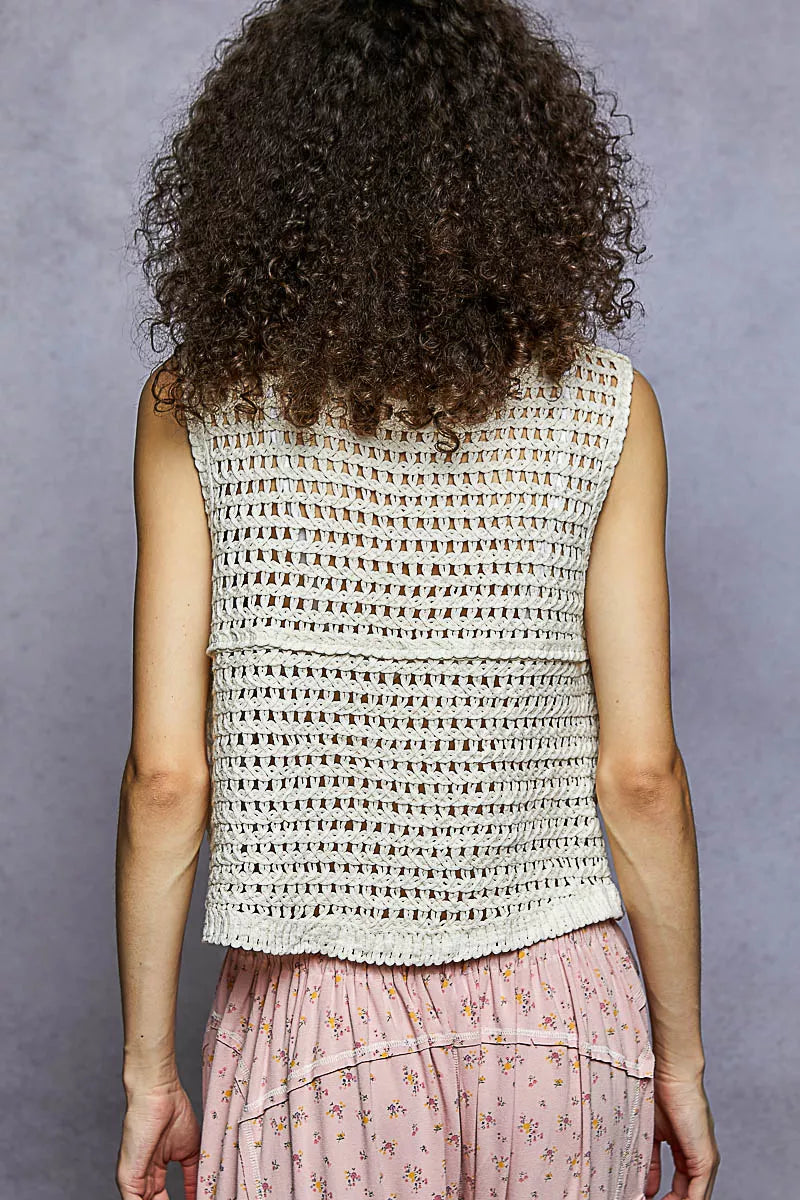 Textured open-back sleeveless vest with crochet-knit yoke and openwork panels.