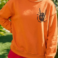 Orange mock neck sweatshirt with skeleton-hand 'Spooky Season' graphic, crew fit