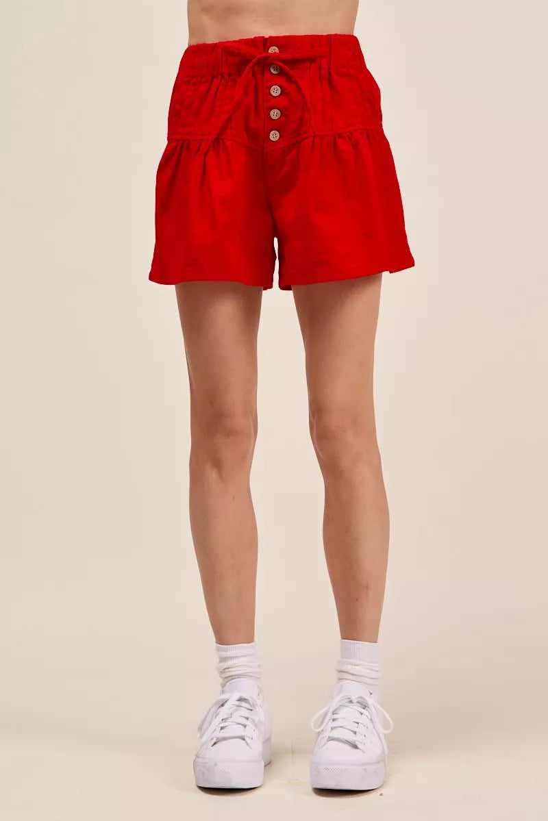 Red denim shorts with elastic waist, button front, and tied waist drawstring.