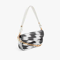 Black and white cowprint shoulder bag with white strap and gold chain, 3/4 view