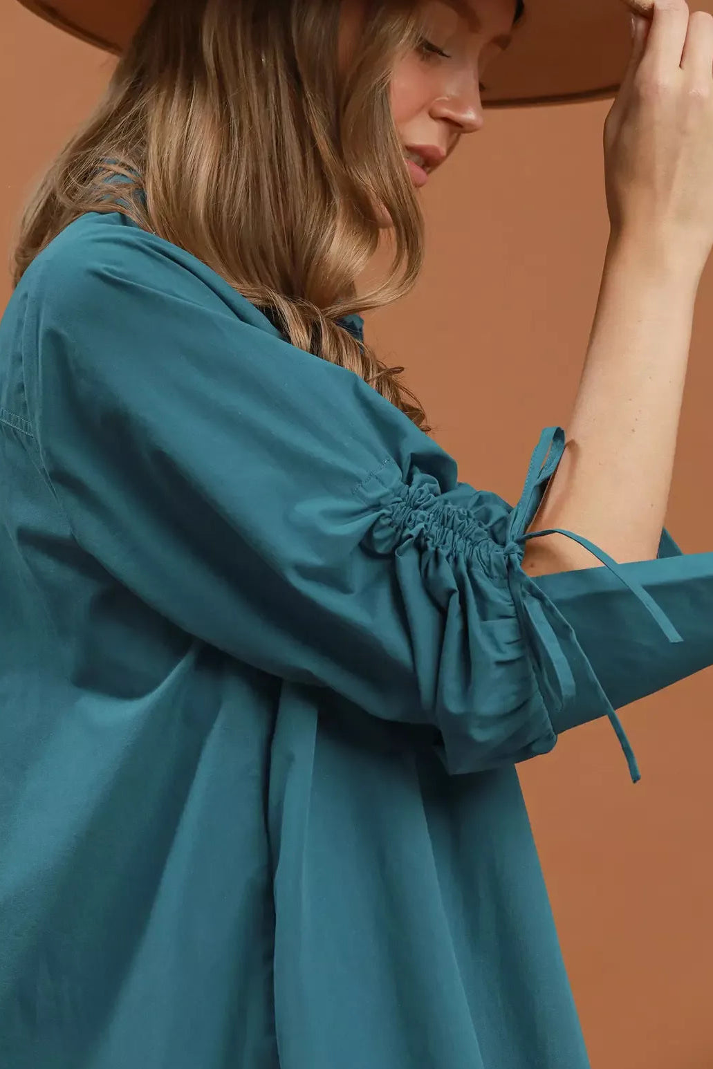 Teal dress sleeve close-up with gathered ruched cuff and button details