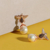 Gold-tone bee drop earrings with crystal wings and white pearl dangles