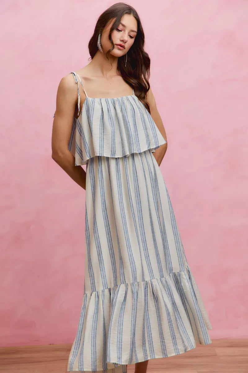 Sleeveless blue-and-white striped midi dress with tie shoulder straps and tiered skirt ruffles