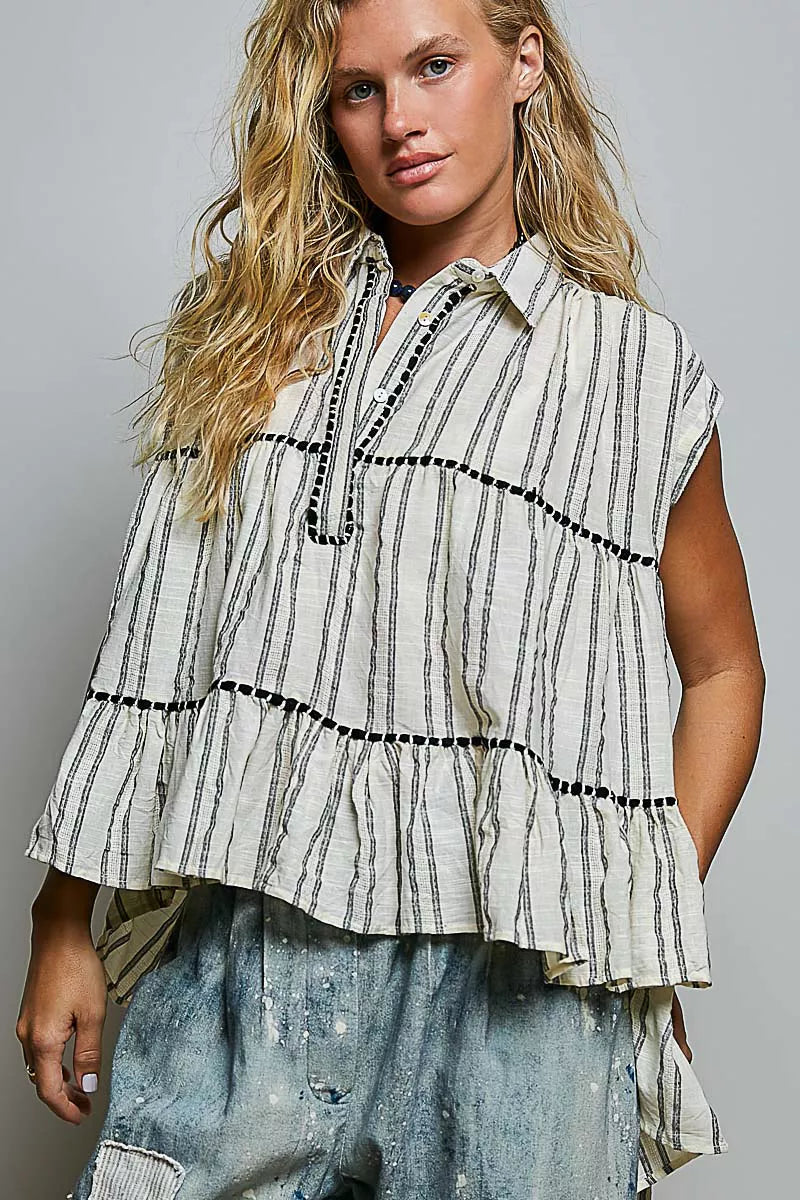 Grey multi-striped sleeveless cotton top with button placket, ruffle tiers, and black trim