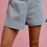 Light blue denim wrap skort with front button, belt loops, and side pockets