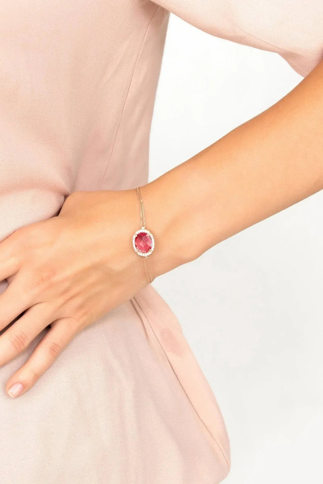 Rose gold pink oval gemstone bracelet worn on wrist