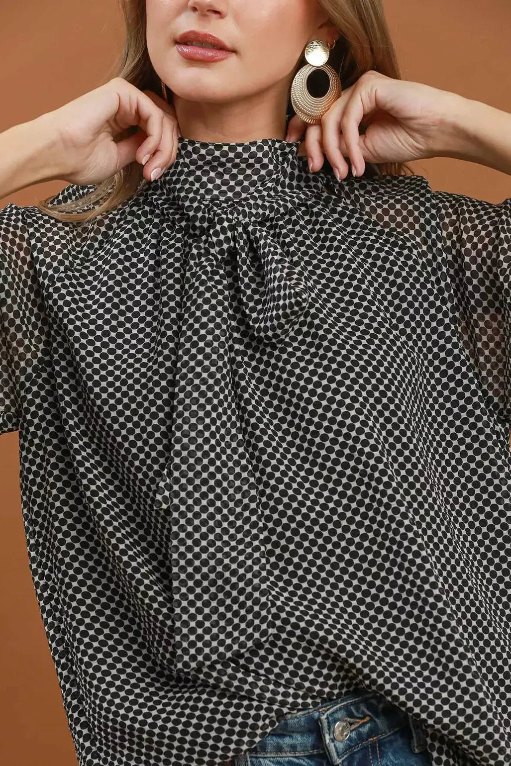 Black and white dot print tie-neck blouse with gathered neckline, front detail