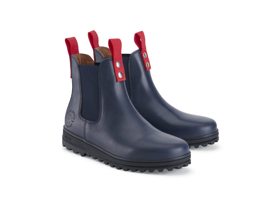 Pair of navy leather Chelsea boots with red pull tabs and lugged soles