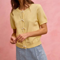 Light blue denim mini skirt with lace ribbon bow accents at the hem.