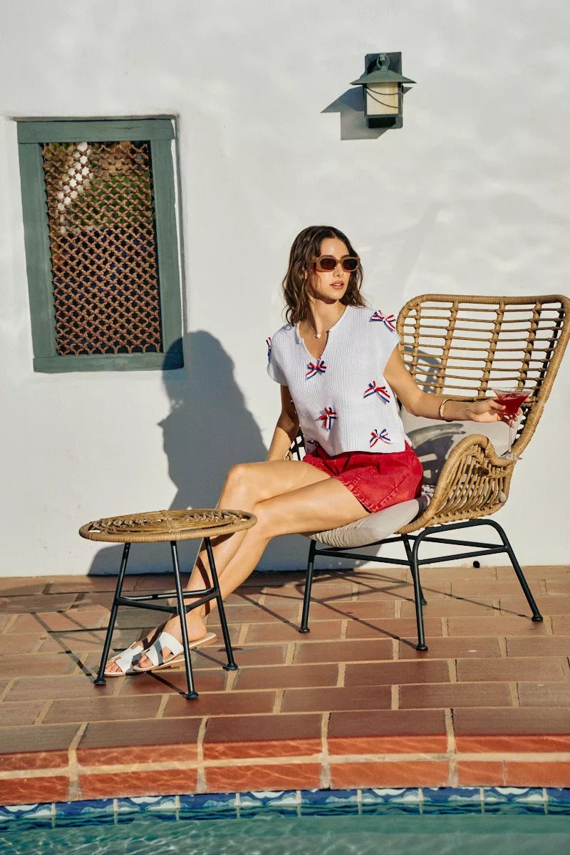 Off-white knit dolman sweater with red, white, and blue ribbon bow details