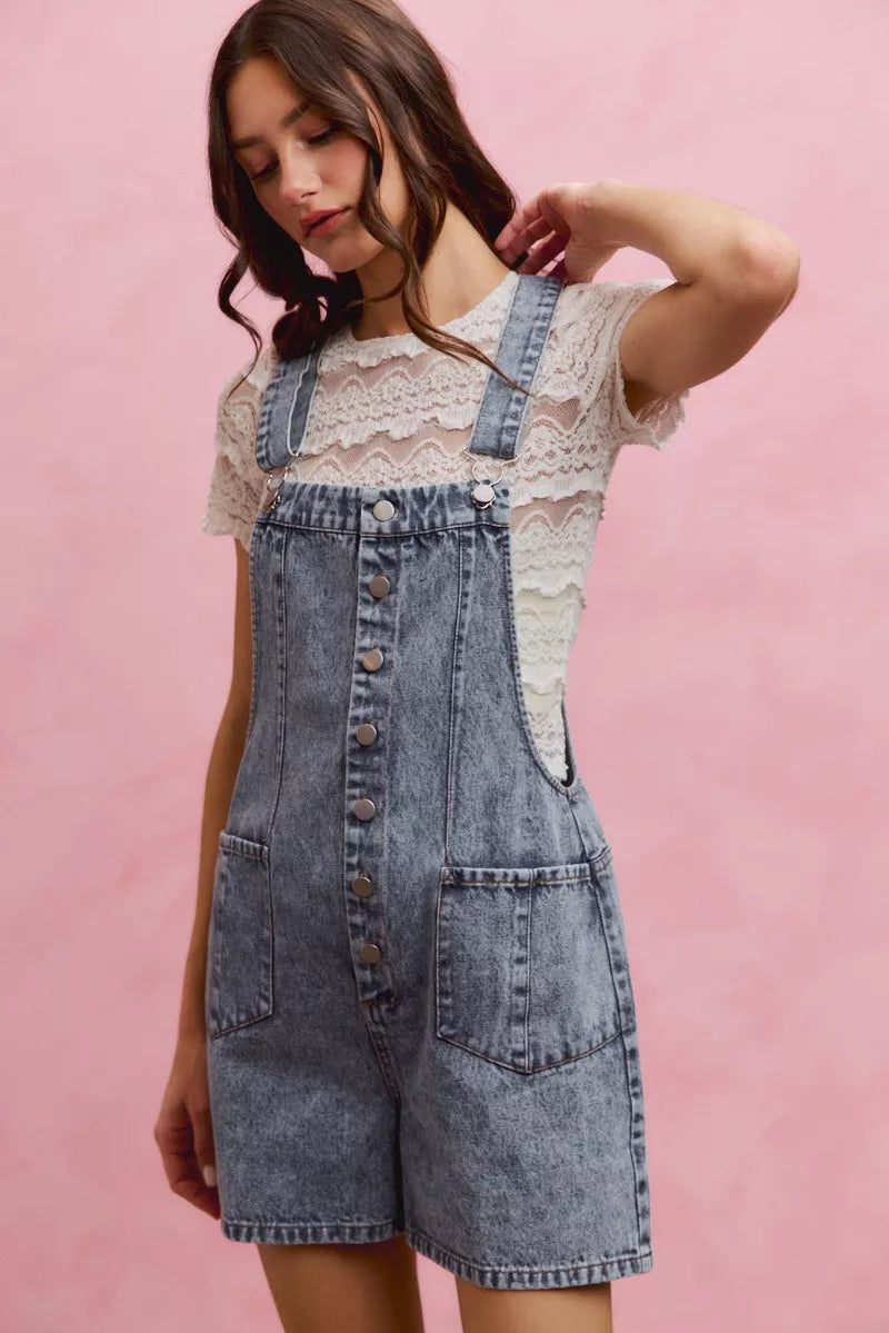 Light wash denim overall romper with adjustable straps and front buttons, front slant pockets